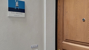 Una porta amb acabat de fusta, un mànec de bronze i una clau.