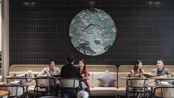 A restaurant with a large decorative clock, multiple seating areas, and a modern interior design.