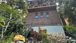 A two-story building with a balcony, number 501, surrounded by lush vegetation and a stone wall. - Modern-Rustic Canyon Studio with Kitchen Close to Hiking in Los Angeles. (Sierra Madre)