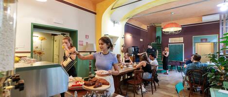 A restaurant with a counter, dining tables, and chairs.