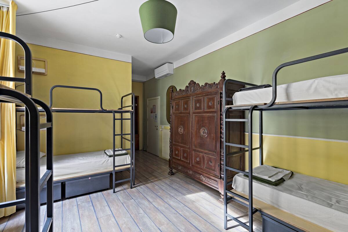 Un dormitorio con literas, un armario de madera y un ventilador de techo.