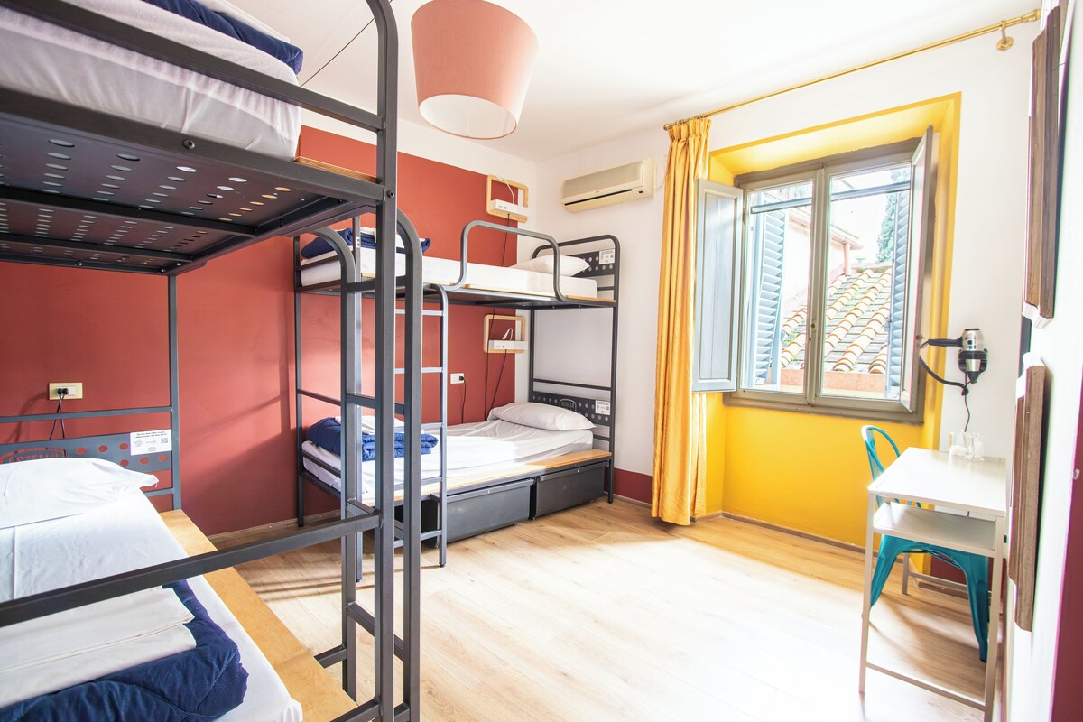 Une chambre de dortoir avec des lits superposés, un bureau et une chaise.