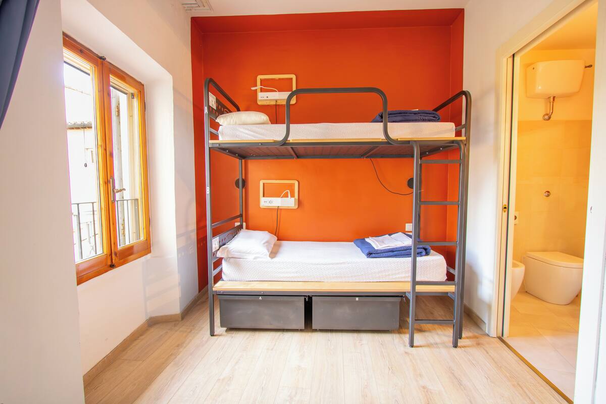 Habitación con literas, ventana y baño.