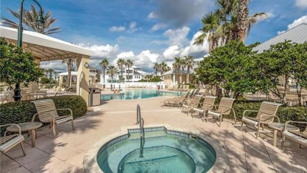 A pool area with lounge chairs, a hot tub, and palm trees. - Luxurious Ocean- Front 5th Floor – 3/3 Corner Unit – Sleeps 8 (Palm Coast)