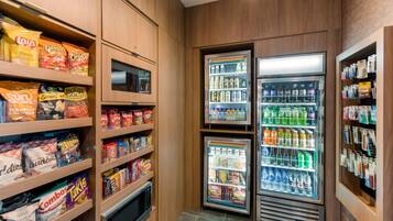 Een automaatruimte met diverse snacks en meerdere drankdispensers.