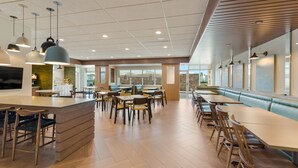 A spacious dining area with multiple tables and chairs, a central island with a counter, and pendant lighting. - Fairfield Inn & Suites by Marriott Columbus Canal Winchester (Canal Winchester)
