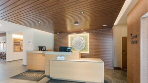 A reception area with a wooden ceiling, a reception desk, and a wall-mounted decorative piece. - Fairfield Inn & Suites by Marriott Columbus Canal Winchester (Canal Winchester)