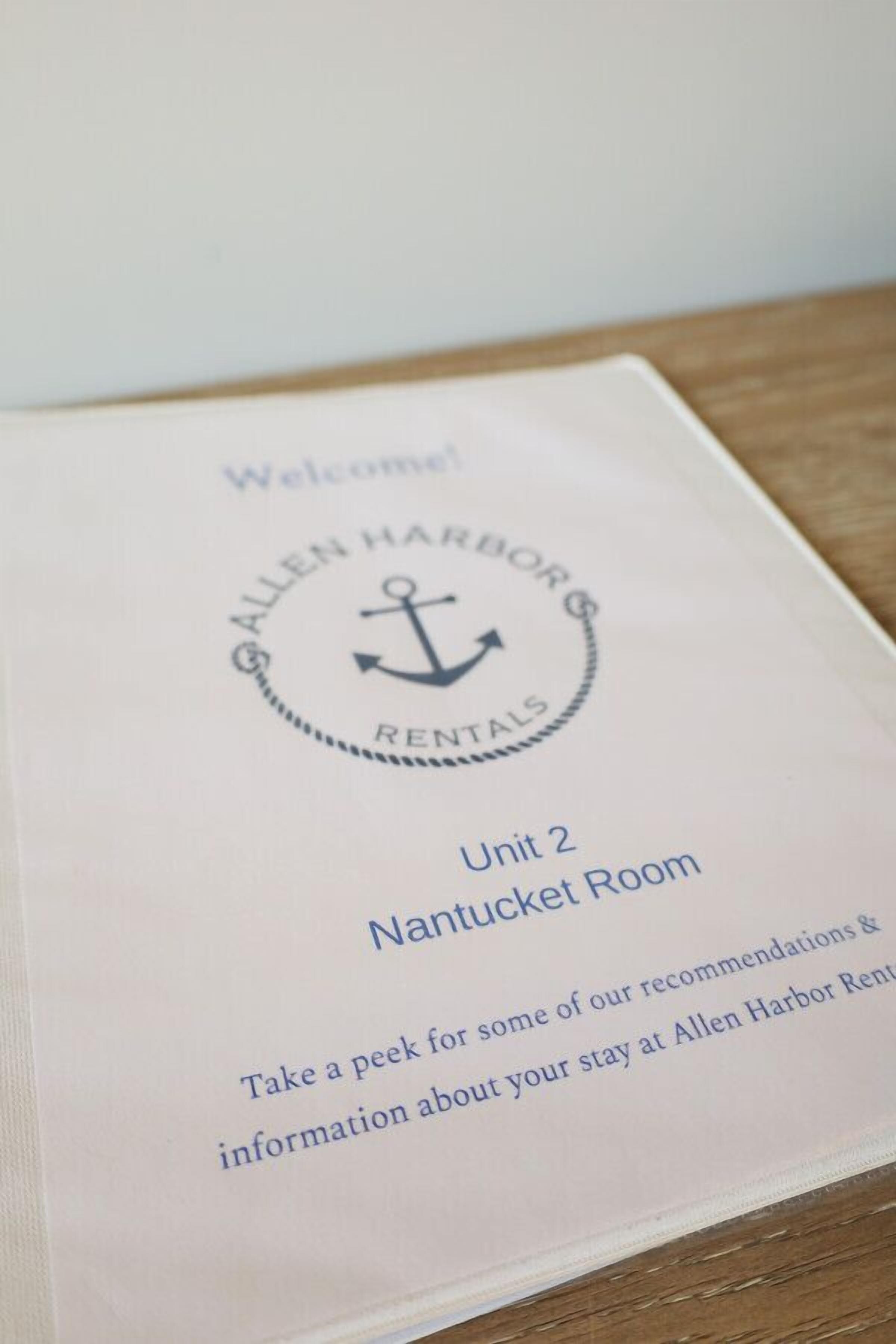 A welcome sign for Allen Harbor Rentals, Unit 2, Nantucket Room, inviting guests to take a peek for recommendations and information about their stay.