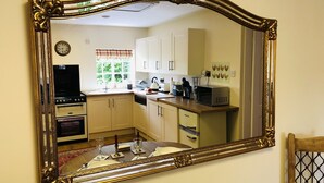 A kitchen with white cabinets, a microwave, and a clock on the wall.