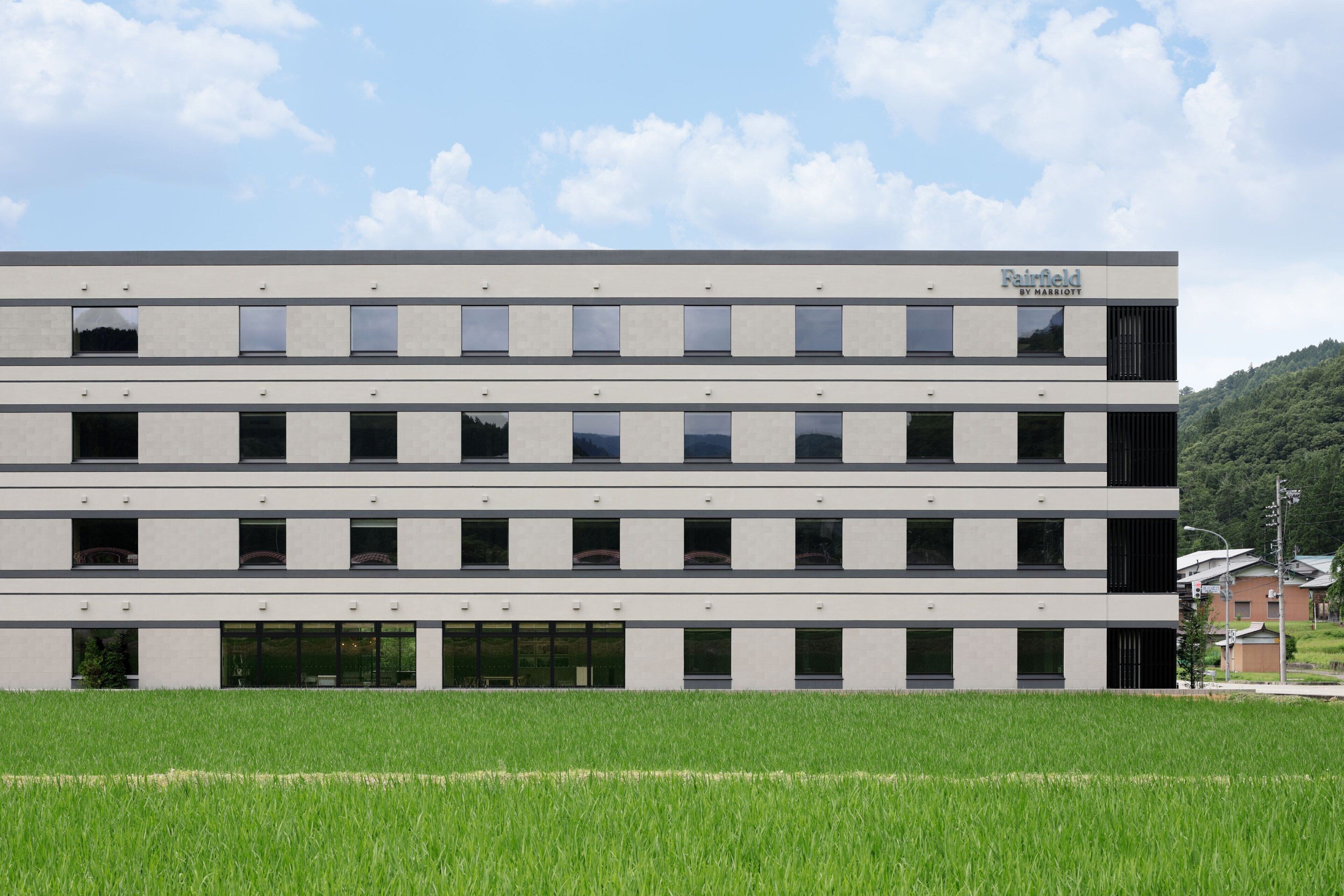 A multi-story building with a flat roof and a sign that reads "Fairfield by Marriott."