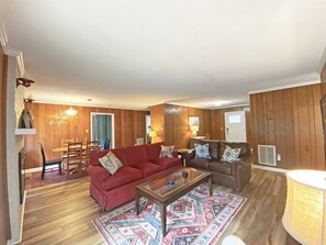 Relax in this open-plan living area with a sofa, coffee table, and dining space.