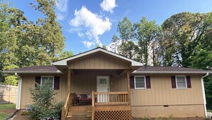 A two-story house with a front porch, a small deck, and a front yard. - Cozy Lake Hartwell Cottage near Tugaloo State Park (Lavonia)
