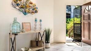 A wooden console table with decorative items, a framed picture, and a wicker basket.