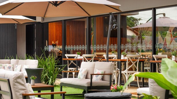 An outdoor seating area with multiple tables and chairs, some with umbrellas. - Pousada Flores do Carmo (Pirenópolis)