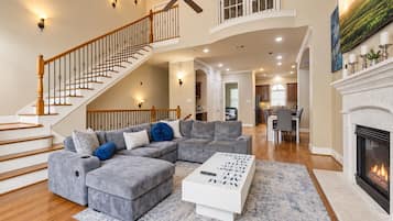 A spacious living room with a sectional sofa, a coffee table, and a fireplace.