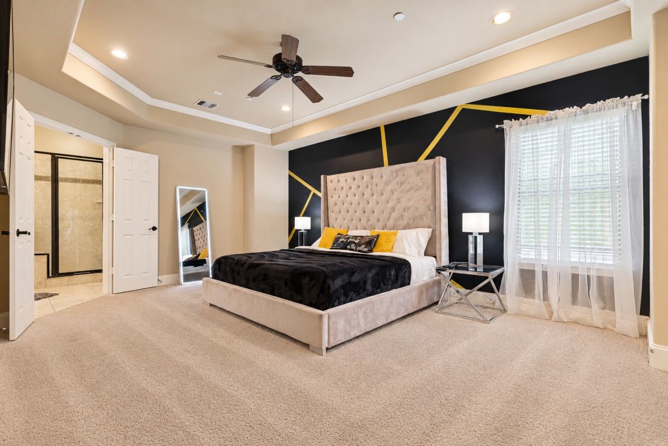 Spacious third-floor primary suite featuring a plush king-size bed, 75” Smart TV, ceiling fan, and plenty of room to unwind.