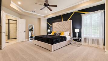 Spacious third-floor primary suite featuring a plush king-size bed, 75” Smart TV, ceiling fan, and plenty of room to unwind.