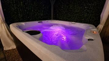Private backyard hot tub tucked beneath a pergola, creating a relaxing outdoor retreat to enjoy throughout your stay.
