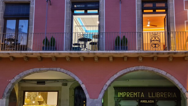 A building with a red facade, multiple windows, and balconies.