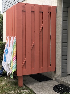 Une clôture en bois rouge sur laquelle sont suspendues des serviettes.