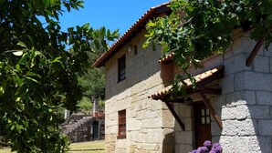 A stone building with a tiled roof, a small window, and a door. - Casa de Campo, Casa do Batocal (Fataunços)