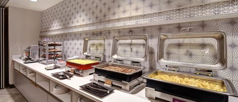 Montaje de bufé con diversos alimentos y utensilios.