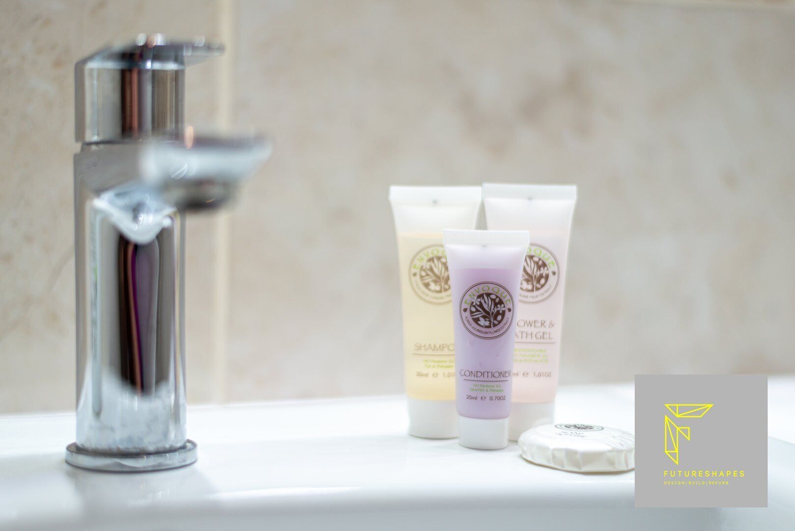 A bathroom sink with three toiletry bottles and a soap bar.