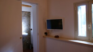 A bathroom with a white sink, a television mounted on the wall, and a window with a view of the outside. - Karrua House cottage with pool in Modica (Modica)