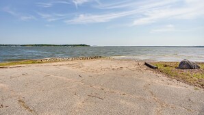 Una zona de playa pavimentada con costa rocosa y una isla distante.