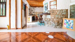 Un intérieur rustique avec un plafond en bois, des murs en pierre et un sol carrelé.