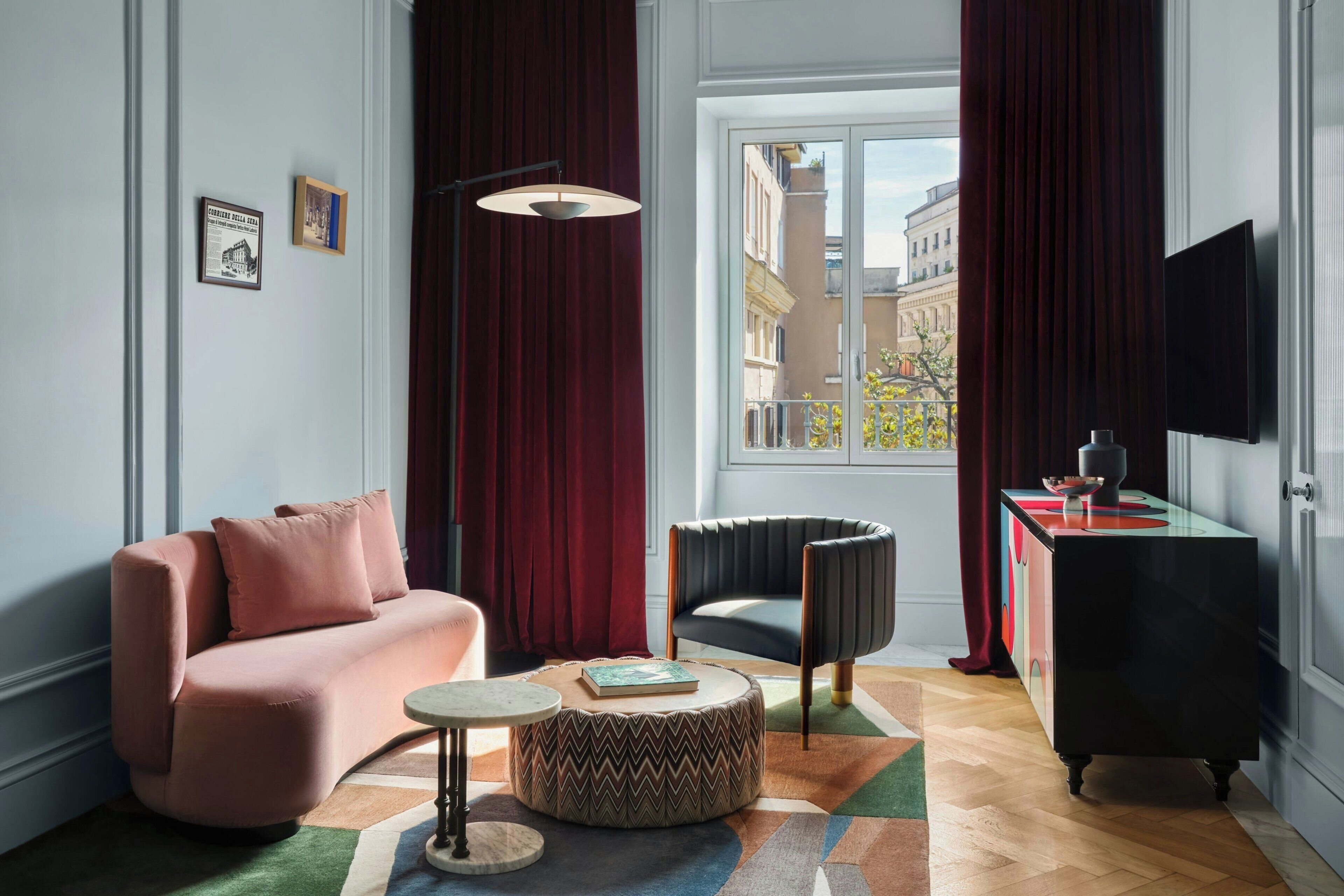 Un salon moderne avec un canapé, un fauteuil, une table basse et un téléviseur posé sur un meuble.