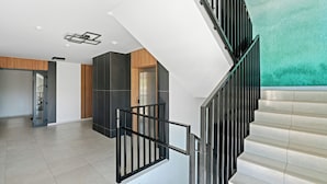 A modern interior with a staircase, a wooden door, and a teal wall. - HoliApart w Nautikka Park (Krynica Morska)