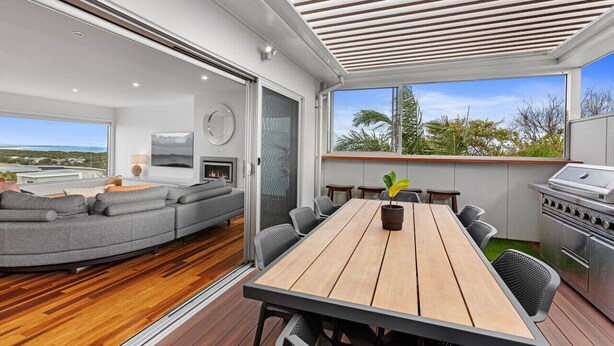 A modern living room with a sofa, a dining table, and a grill. - Luxurious Terrace Hideaway with Heated Pool (Ocean Grove)