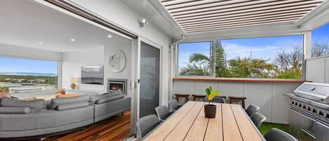 Un salon moderne avec un canapé, une table à manger et un barbecue.