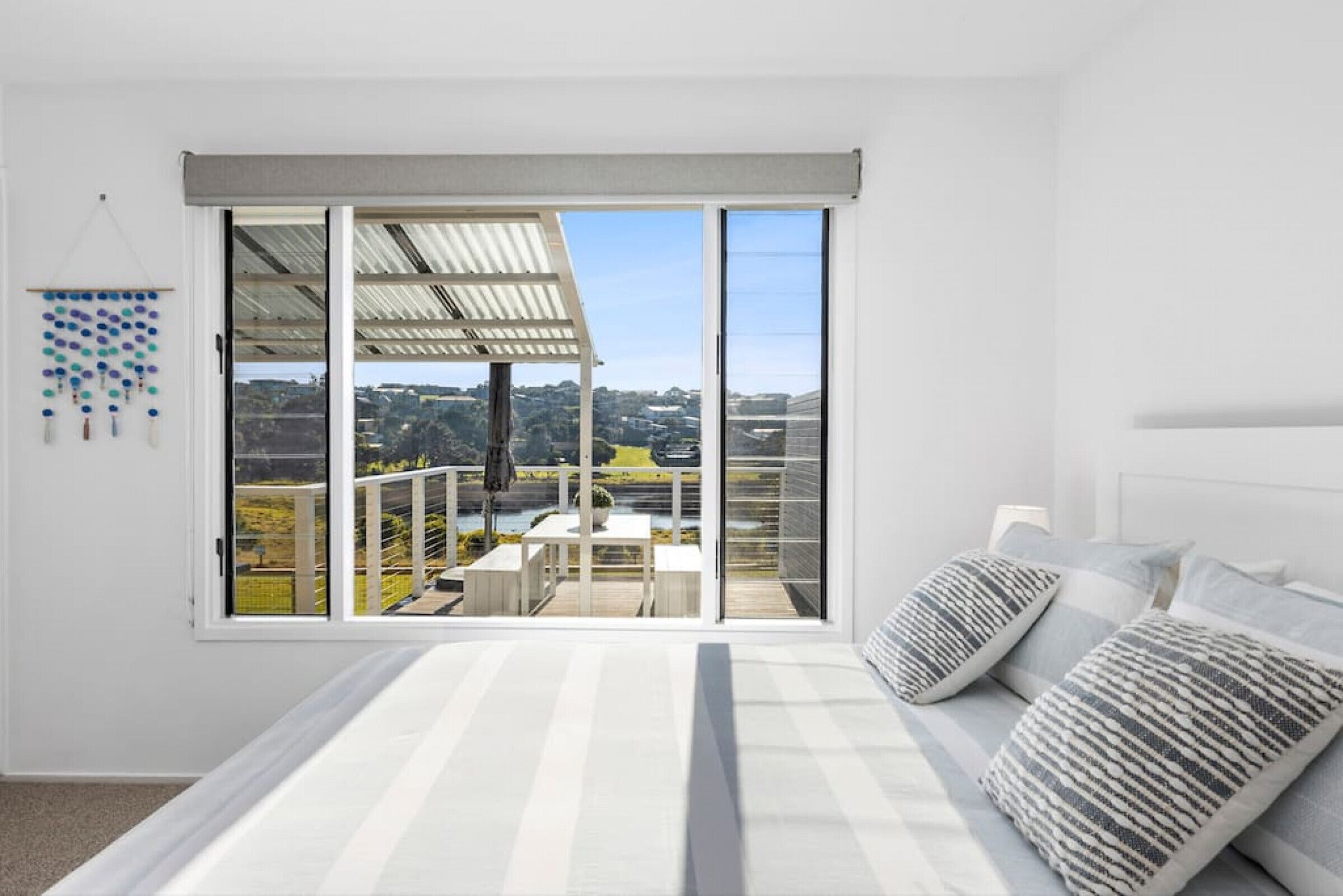 Un dormitorio con un gran ventanal corredera que da a un balcón con vistas al campo.