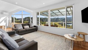 Un salon spacieux doté d’une grande fenêtre offrant une vue panoramique, d’un canapé confortable et d’une petite table en bois.