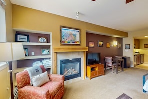 Cozy living space with a fireplace, comfortable seating, and a TV, perfect for relaxation and entertainment.
