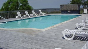 A pool area with lounge chairs and a wooden deck. - Oceanfront townhome with sound access in Duck! (Duck)