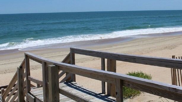A wooden boardwalk leading to a sandy beach with the ocean in the background. - Oceanfront townhome with sound access in Duck! (Duck)