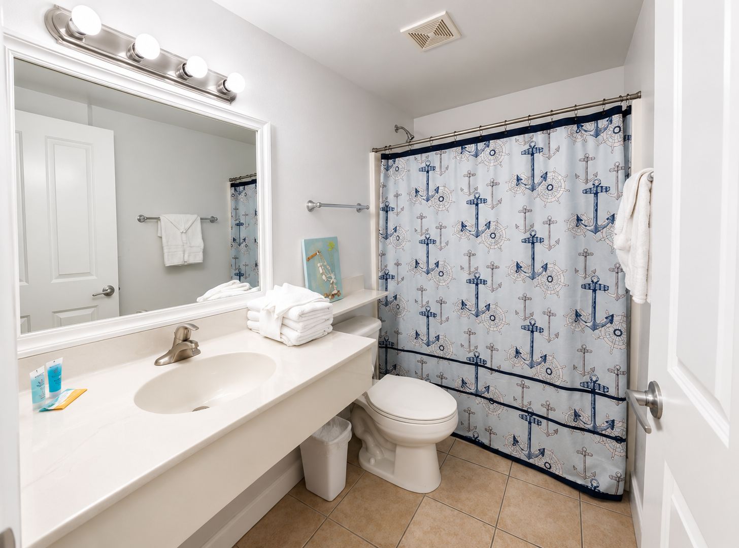 Un baño con lavamanos, espejo e inodoro.