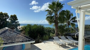 A pool area with lounge chairs and a view of the ocean. -  MAGNIFIQUE VILLA KYLA'S  the most beautiful sea view in the Caribbean with POOL (Collectivity of Saint Martin)