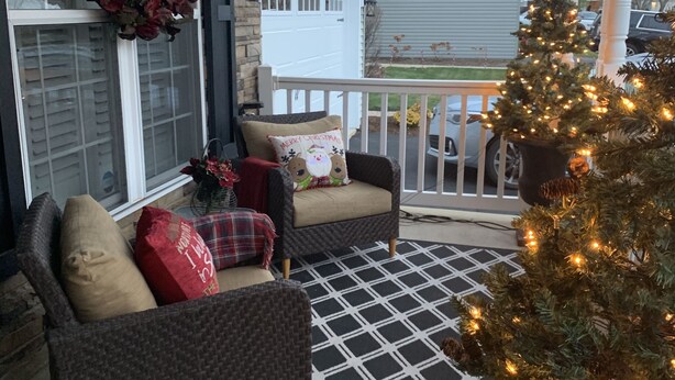 A porch with a Christmas tree, wicker furniture, and a patterned rug. - Idyllic Country Living (Geneva)