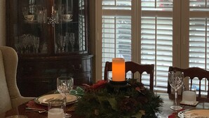 A dining room with a chandelier, a wooden cabinet, and a table set for a meal. - Idyllic Country Living (Geneva)