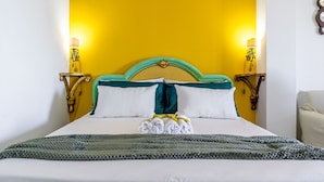 Ein Bett mit einem grünen Kopfteil, weißen Kissen und einer grünen Strickdecke.