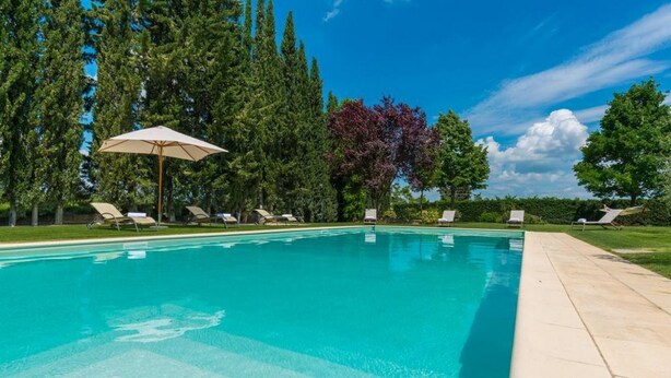 A swimming pool with lounge chairs and an umbrella, surrounded by trees. - Santa Margherita - NINFEA (Poggibonsi)