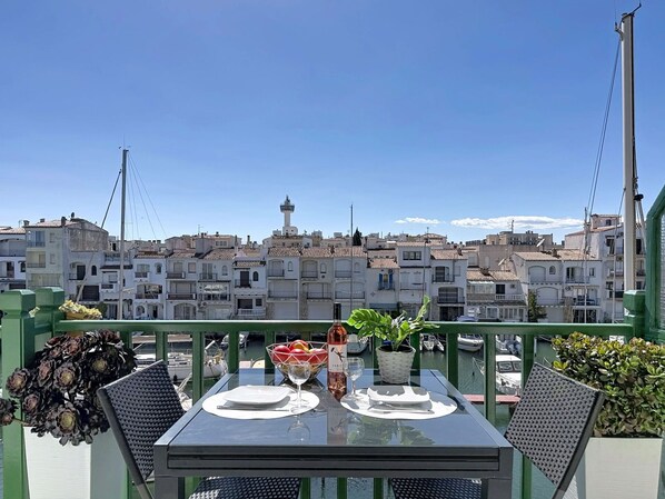 A table set for two on a balcony with a view of a cityscape.