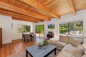 Relax in this serene living space with a fireplace, garden views, and a comfortable sofa.