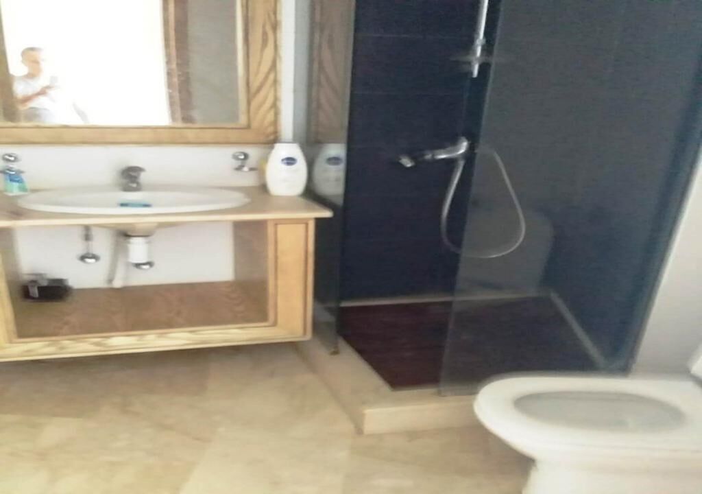 Un baño con lavamanos, espejo y retrete.