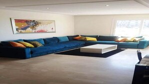 Una sala de estar moderna con un sofá seccional, una mesa de centro y un cuadro en la pared.