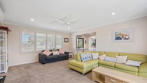 Ein Wohnzimmer mit Deckenventilator, zwei Sofas, einem Couchtisch und einem gerahmten Bild an der Wand.